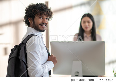 Young man standing near reception and asking something Young man standing near reception and asking something 93693302