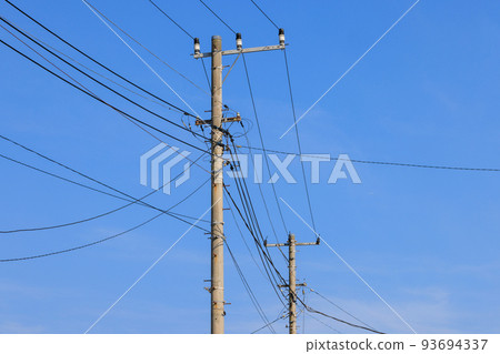 Electric poles and wires drawing line drawings in the blue sky Electric poles and wires drawing line drawings in the blue sky 93694337