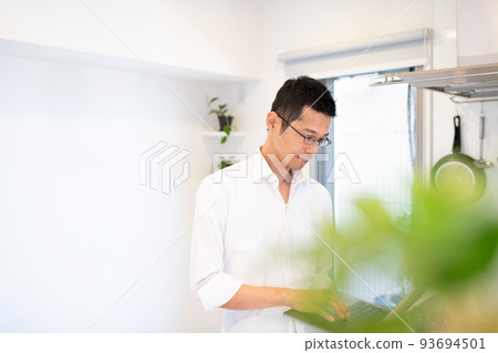在廚房裡用電腦工作的人 在廚房裡用電腦工作的人 93694501