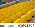 yellow empty seats at a sports stadium 93694807