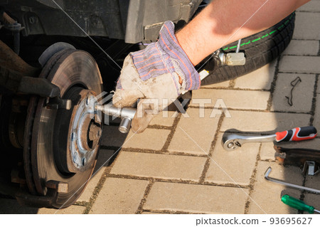 Technician is using a wrench to remove the locking nut of Brake caliper in service shop maintenance concept brake system. Technician is using a wrench to remove the locking nut of Brake caliper in service shop maintenance concept brake system. 93695627