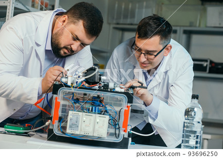 Two scientists are working on the development of a new device Two scientists are working on the development of a new device 93696250