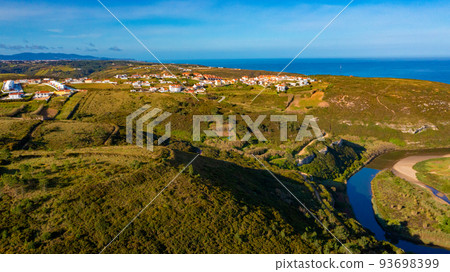 Top view of a European town with beautiful green landscape during sunset. Drone view of a beautiful small European city with a beautiful hilly landscape while sunset.  Portugal. 93698399