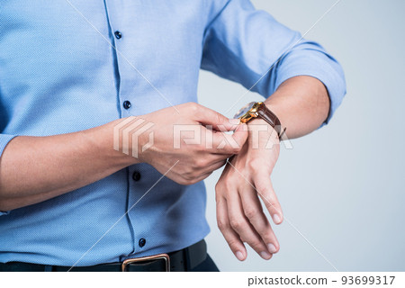 Setting clock going. Man wind wrist watch grey background. Portable timepiece. Time management. Deadline. Clock is ticking Setting clock going. Man wind wrist watch grey background. Portable timepiece. Time management. Deadline. Clock is ticking 93699317