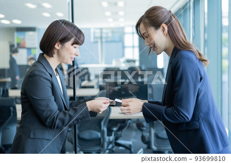 兩名職業女性在會議室交換名片 93699810