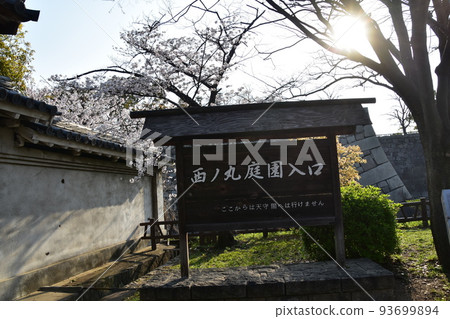 日本大阪府,春天的大阪城,盛開的櫻花和城牆,指示牌上寫著西之丸花園入口 日本大阪府,春天的大阪城,盛開的櫻花和城牆,指示牌上寫著西之丸花園入口 93699894