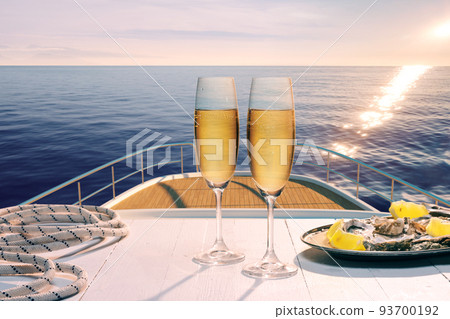 Exotic country voyage. Champagne flutes glasses on deck of luxury cruise ship during honeymoon holidays. Love, travel, vivid impressions Exotic country voyage. Champagne flutes glasses on deck of luxury cruise ship during honeymoon holidays. Love, travel, vivid impressions 93700192