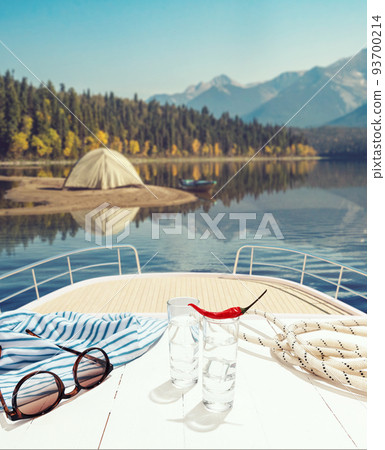Summer river trip. Two shots of vodka with hot pepper on deck of private yacht, boat sea, nature landscape. Nature, love, travel, emotions, vivid impressions 93700214