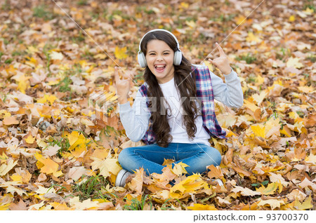 Going crazy. childhood happiness. beauty and nature. happy kid wear headphones. teen girl listen music on the way to school. child relax in autumn forest. fall maple leaves in park. online education Going crazy. childhood happiness. beauty and nature. happy kid wear headphones. teen girl listen music on the way to school. child relax in autumn forest. fall maple leaves in park. online education 93700370