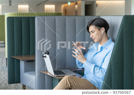 A young man having a web conference on a computer in his office work booth.Photography cooperation "LINK FOREST" A young man having a web conference on a computer in his office work booth.Photography cooperation "LINK FOREST" 93700567
