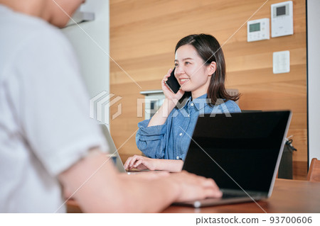 A young woman calling on a smartphone during telework 93700606