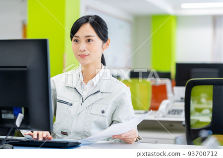 Young woman in work clothes working in the office Young woman in work clothes working in the office 93700712