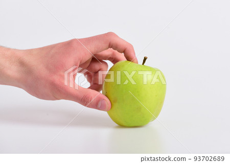 Hand holds apple fruit isolated on light grey background 93702689