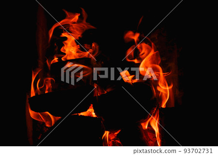 Burning firewood and coals in a stone stove. Brick oven on wood. Long tongues of flame of burning fire Burning firewood and coals in a stone stove. Brick oven on wood. Long tongues of flame of burning fire 93702731