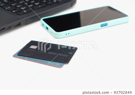 Online shopping and e-payments concept. Laptop, cellphone and credit card for online shopping on a white table. Online shopping and e-payments concept. Laptop, cellphone and credit card for online shopping on a white table. 93702849