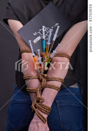 Vertical shot back view of bound girl hostage of heroine drug concept. Drug addiction dependence concept. 93703659