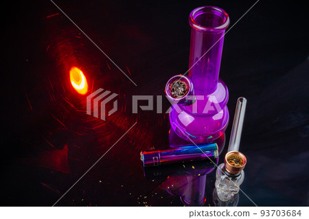 Purple glass bong with lighter and smoking pipe. Marijuana weed smoke accessories. Purple glass bong with lighter and smoking pipe. Marijuana weed smoke accessories. 93703684