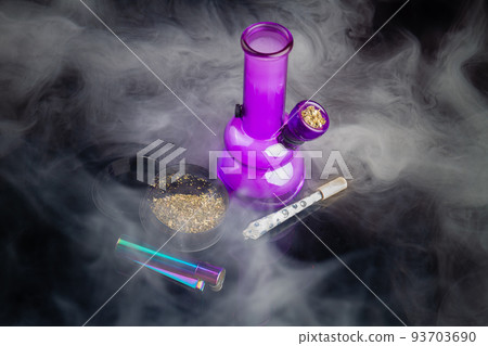Purple glass bong with joint and a lot of thick white smoke. Top view marijuana weed addiction concept. Purple glass bong with joint and a lot of thick white smoke. Top view marijuana weed addiction concept. 93703690