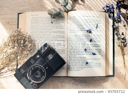 Dried flowers, foreign books and a camera 93703712