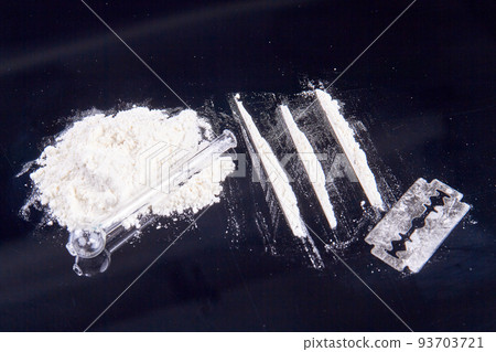 Pile of white powder drugs and glass smoking pipe. Razor and cocaine lines for snorting. Pile of white powder drugs and glass smoking pipe. Razor and cocaine lines for snorting. 93703721