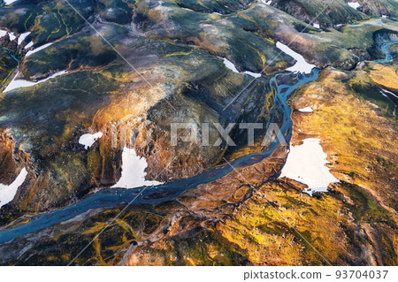 Scenic surreal volcanic mountain with river through lava field located remote in Highlands of Iceland 93704037