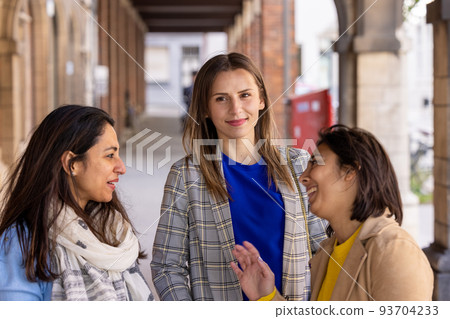 Multiracial group of girls walking in the city. Urban background with busy road and sidewalk 93704233