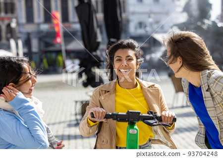 happy young company of talking smiling multiracial friends in the city, female friends having fun 93704248