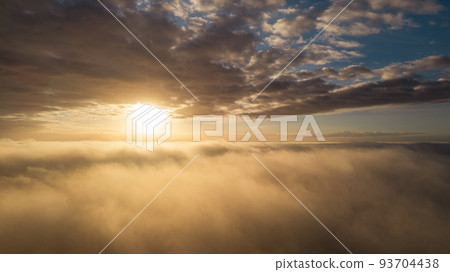 Aerial View. Flying in fog, fly in mist over the early morning clouds in the rising sun. Aerial 93704438