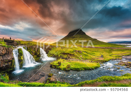 Landscape of sunset over Kirkjufell mountain with Kirkjufellsfoss waterfall and colorful pileus cloud on summer at Iceland 93704568