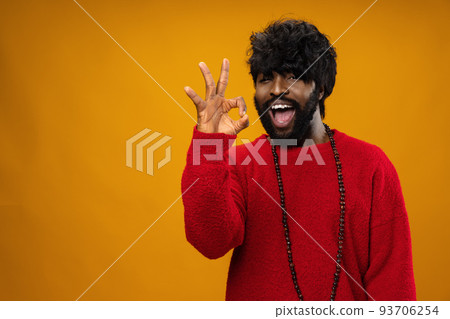 Black man showing ok sign against yellow background Black man showing ok sign against yellow background 93706254
