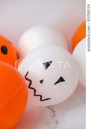Painted Jacks face on balloons. Orange and white balls preparation diy for halloween party. Halloween home activities. Handmade toys 93706514