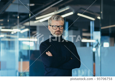 Senior gray haired banker, portrait of successful thinking businessman man in modern office with wrinkled hands in glasses looking at camera Senior gray haired banker, portrait of successful thinking businessman man in modern office with wrinkled hands in glasses looking at camera 93706758