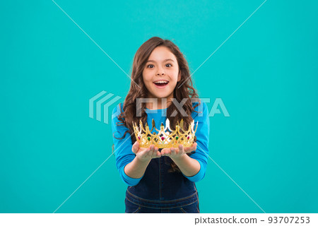My biggest treasure. Kid hold golden crown symbol of princess. Childhood concept. Every girl dreaming to become princess. Lady little princess. Girl cute baby hold crown while stand blue background My biggest treasure. Kid hold golden crown symbol of princess. Childhood concept. Every girl dreaming to become princess. Lady little princess. Girl cute baby hold crown while stand blue background 93707253