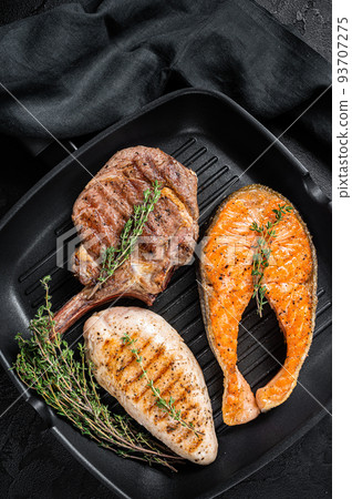 Grilled steaks. Beef rib eye, salmon and Turkey breast. Organic fish, poultry and beef meat. Black background. Top view Grilled steaks. Beef rib eye, salmon and Turkey breast. Organic fish, poultry and beef meat. Black background. Top view 93707275
