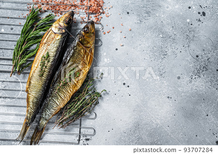 Smoked kippered whole herrings on smoker grill. Gray background. Top view. Copy space Smoked kippered whole herrings on smoker grill. Gray background. Top view. Copy space 93707284