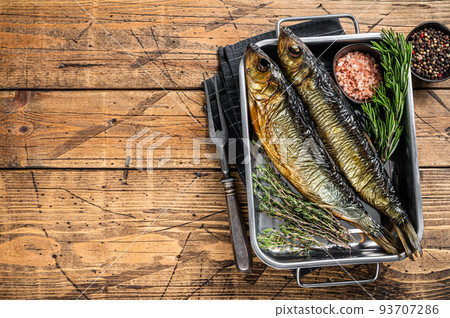 Smoked marinated herring fish in kitchen tray with herbs. Wooden background. Top view. Copy space Smoked marinated herring fish in kitchen tray with herbs. Wooden background. Top view. Copy space 93707286
