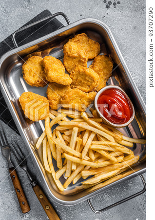Fried crispy chicken nuggets with ketchup and French fries. Gray background. Top view Fried crispy chicken nuggets with ketchup and French fries. Gray background. Top view 93707290