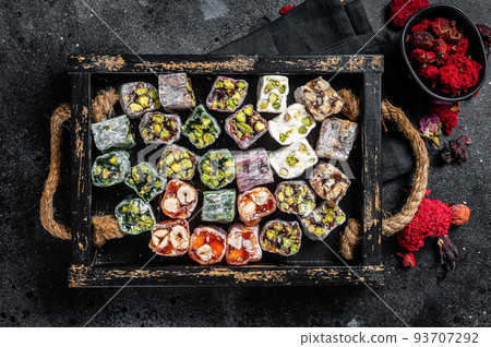 Turkish Delight Lukum, Oriental sweets with nuts and black tea. Black background. Top view Turkish Delight Lukum, Oriental sweets with nuts and black tea. Black background. Top view 93707292