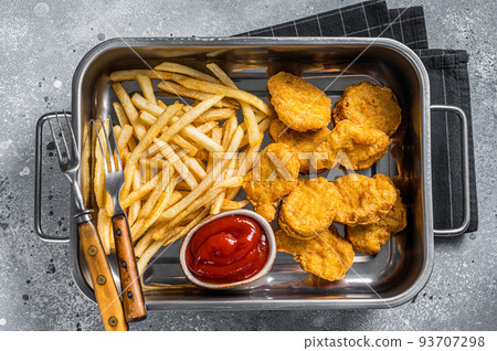 Fried crispy chicken nuggets with ketchup and French fries. Gray background. Top view Fried crispy chicken nuggets with ketchup and French fries. Gray background. Top view 93707298