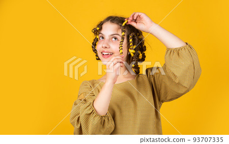 Fashion and beauty. Small girl hairdresser salon. Little child curly hair. Hairstyle for party. Beautiful Healthy hair. Enjoying shiny curls. Balm oil conditioner for styling. Hairdresser supplies Fashion and beauty. Small girl hairdresser salon. Little child curly hair. Hairstyle for party. Beautiful Healthy hair. Enjoying shiny curls. Balm oil conditioner for styling. Hairdresser supplies 93707335