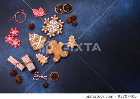 Elements of Christmas decorations, sweets and gingerbread on a wooden cutting board Elements of Christmas decorations, sweets and gingerbread on a wooden cutting board 93707406