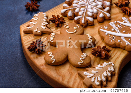 Elements of Christmas decorations, sweets and gingerbread on a wooden cutting board 93707416