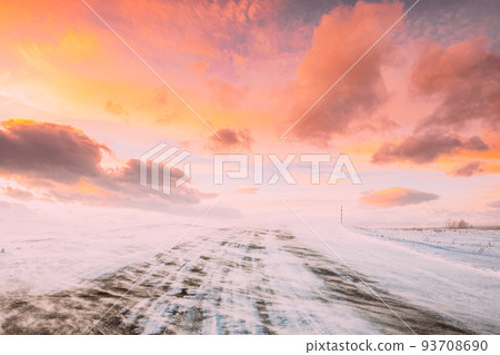 Snow-covered Open Slippy Road During A Snowstorm Blizzard In Winter. Altered Colorful Sunset Sunrise Sky. Dangerous Motion. Strong Wind In Winter Sunny Day. Dangerous Weather Conditions Blizzard In 93708690