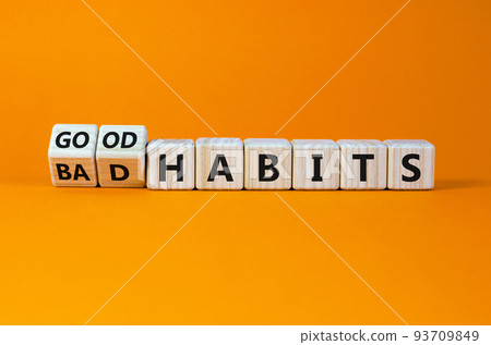 Good or bad habits symbol. Turned wooden cubes, changed words 'bad habits' to 'good habits'. Beautiful orange table, orange background. Business, bad or good habits concept. Copy space. 93709849