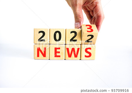 2023 News new year symbol. Businessman turns a wooden cube and changes words News 2022 to News 2023. Beautiful white table white background, copy space. Business 2022 news new year concept. 93709916