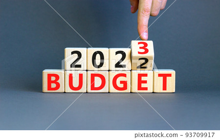 Planning 2023 budget new year symbol. Businessman turns a wooden cube and changes words Budget 2022 to Budget 2023. Beautiful grey background, copy space. Business 2023 budget new year concept. Planning 2023 budget new year symbol. Businessman turns a wooden cube and changes words Budget 2022 to Budget 2023. Beautiful grey background, copy space. Business 2023 budget new year concept. 93709917