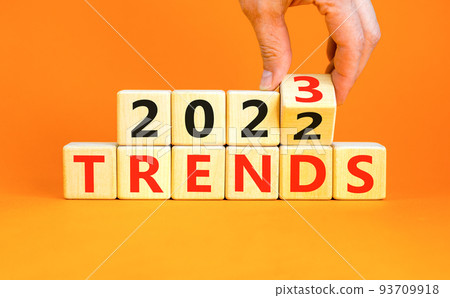 2023 review new year symbol. Businessman turns a wooden cube and changes words Review 2022 to Review 2023. Beautiful orange table orange background, copy space. Business 2023 review new year concept. 93709918