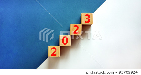 2023 happy new year symbol. Wooden cubes symbolize the change from 2022 to the new year 2023. Beautiful white and blue background. Copy space. Business and 2023 happy new year concept. 93709924