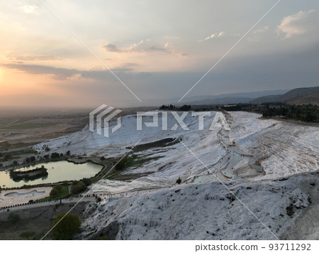 Pamukkale Travertines Cinematic Aerial Drone footage. Turkish famous white thermal bath with healthy clean water in a beautiful sunset.  93711292