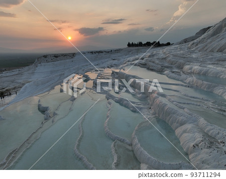 Pamukkale Travertines Cinematic Aerial Drone footage. Turkish famous white thermal bath with healthy clean water in a beautiful sunset.  93711294